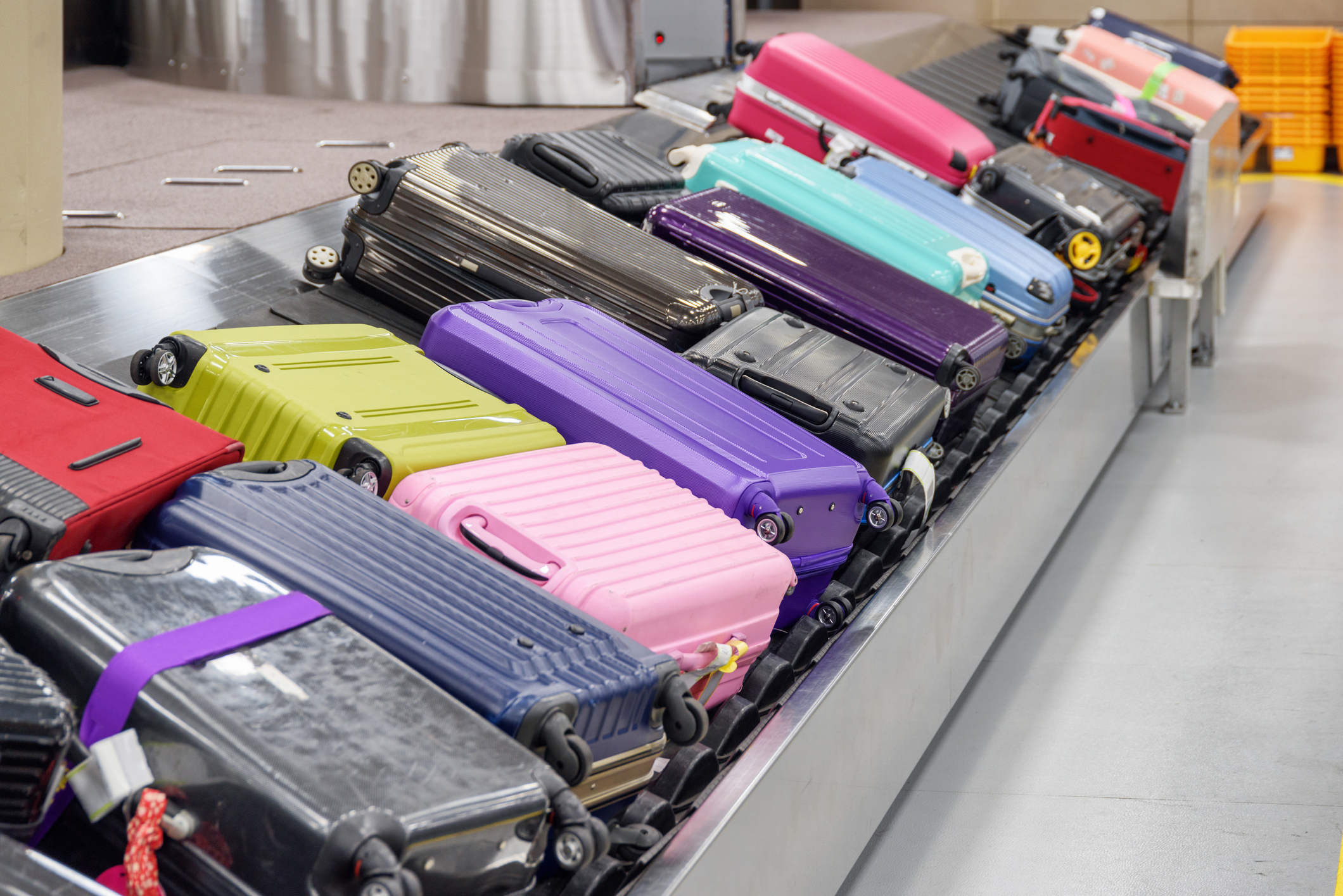 Suitcases pile up in large quantity on a baggage carousel.