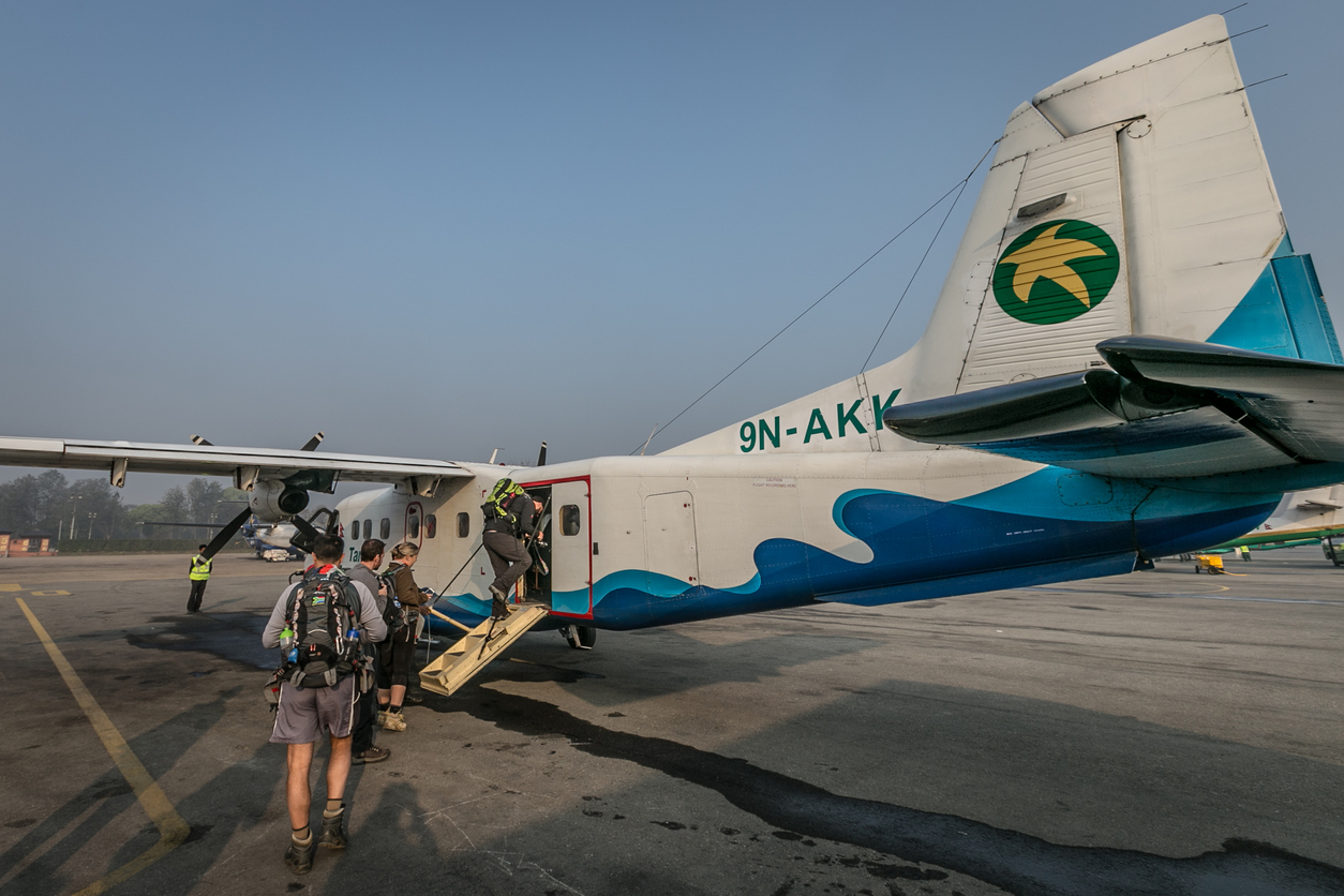A propeller plane in Nepal, passengers are boarding.