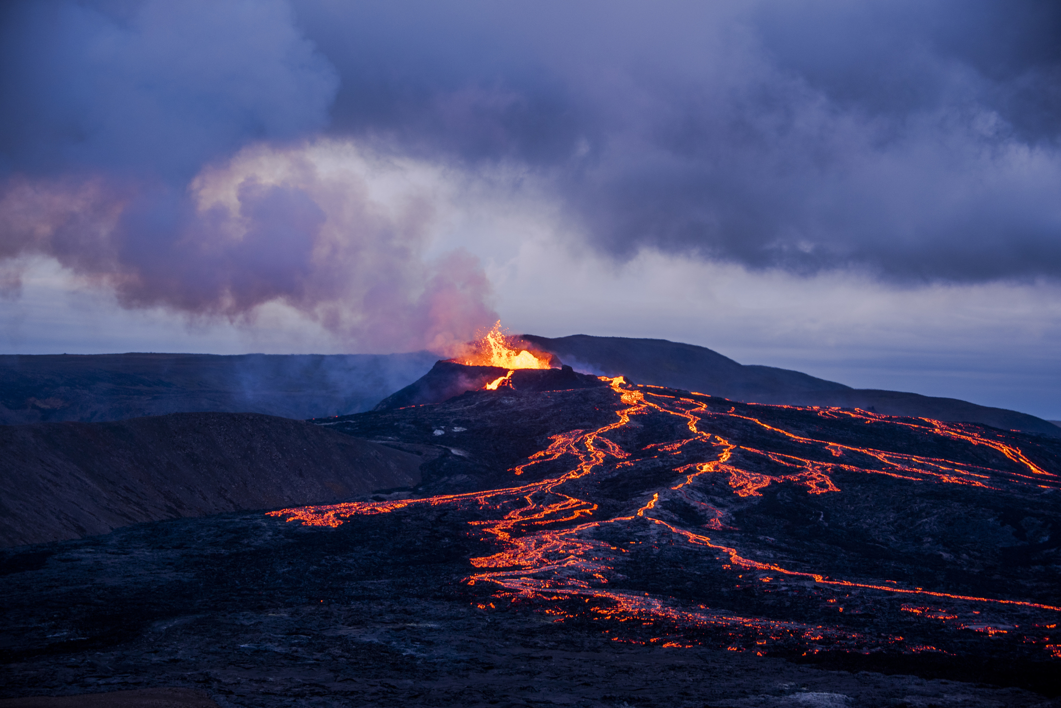 Lava flows and the erupting Eyjafjallajökull at dusk.