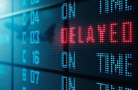 Close-up of an airport display board showing a flight delay.