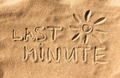 The words “Last Minute” and a sun are drawn in the sand.