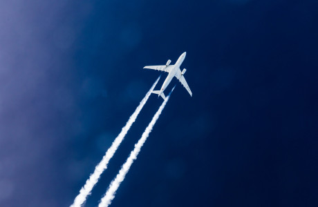 Aircraft in the sky with condensation trails