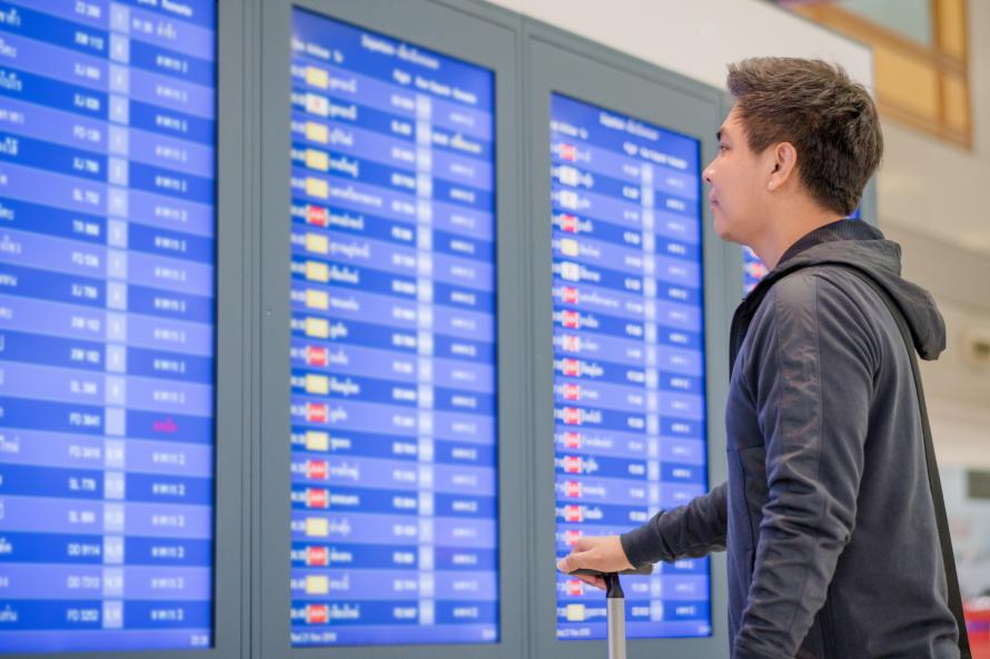 A man looking at a live flight schedule.